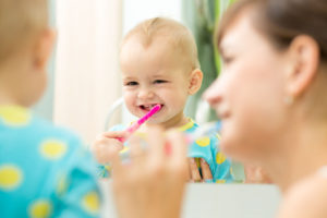 34544965 - mother and kid girl look at mirror during teeth brushing